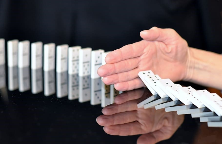 Hand stopping the domino effect halfway