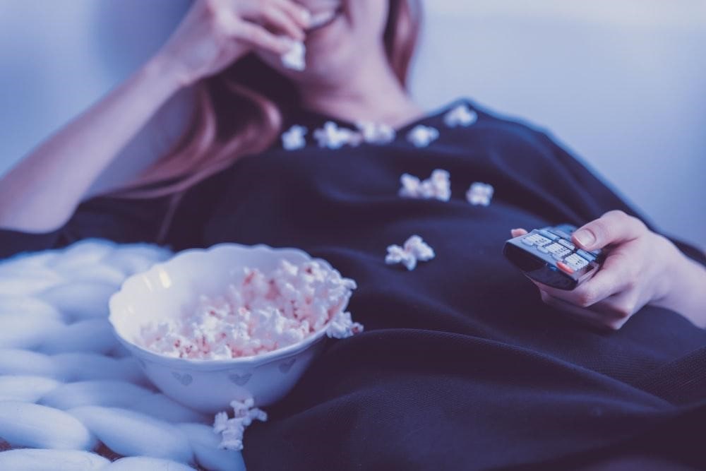 A person eating popcorn while watching a movie