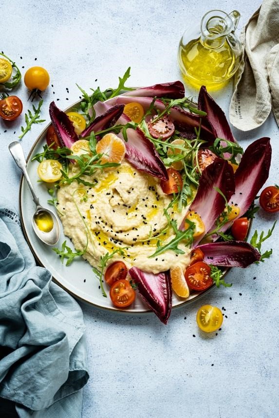 a plate of hummus garnished with vegetables